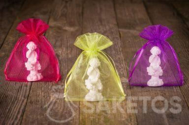 Figurines of angels packed in colorful organza pouch for thanks to wedding guests