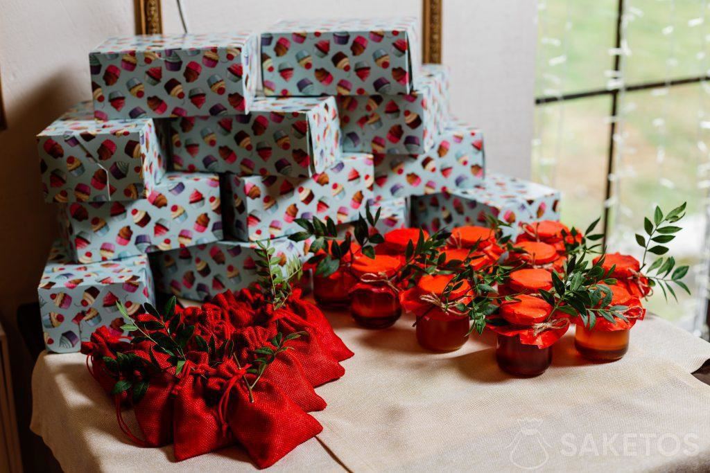 Gift boxes wrapped in colored paper, jute red bags and jars with preserves
