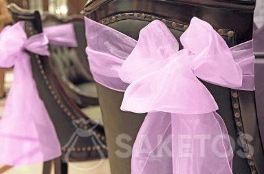 Decorative organza bow tied on the back of a chair