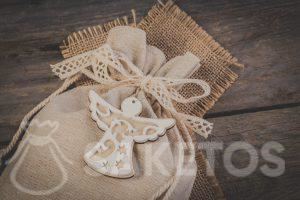 A linen bag tied with a ribbon bow featuring a decorative pendant