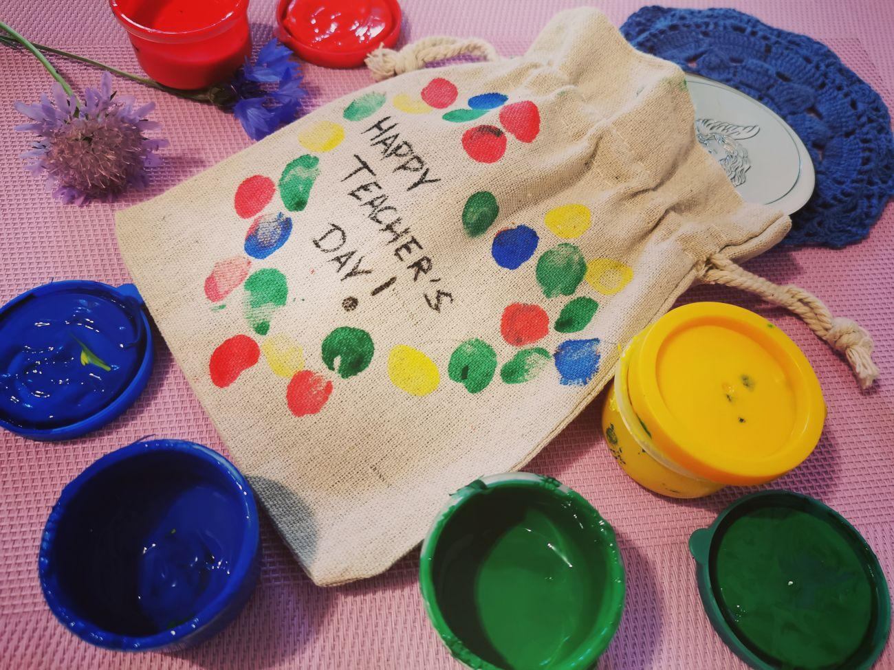 A gift for a teacher in a bag decorated with his students' fingerprints