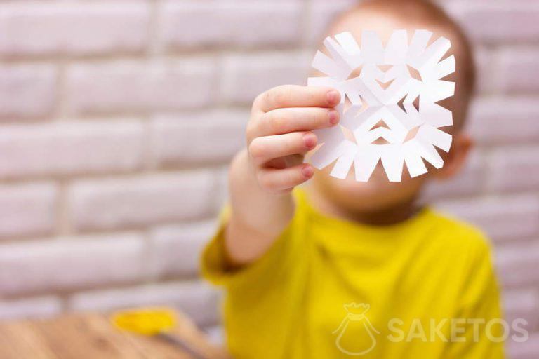 Child cutting out a snowflake from paper