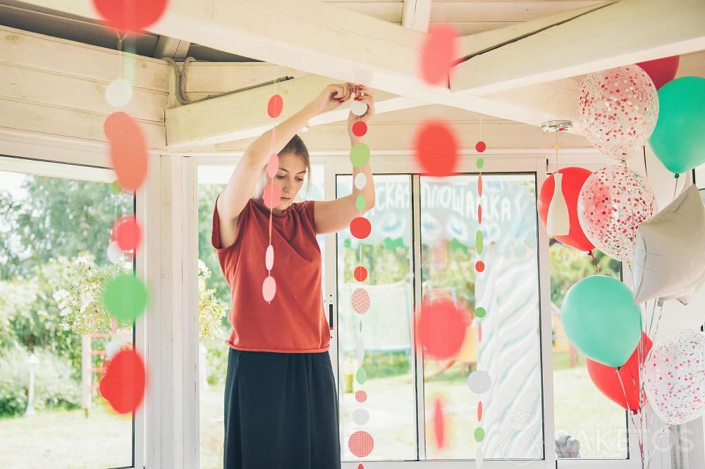 Young woman hanging decorations for a party