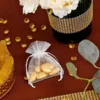 Mini organza pouches with gold almonds, elegant favor.