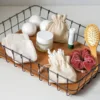 Practical cotton sacks in a wire basket as an eco bathroom organizer.