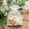 Elegant decorative 10x13 bags on a wedding table among green leaves.