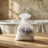 Organza pouch with dried lavender and bath salt next to spa accessories.