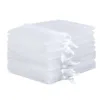 A stack of white organza gift bags for multipurpose packaging.