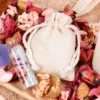 Natural cotton bag with dried flowers and a glass vial.