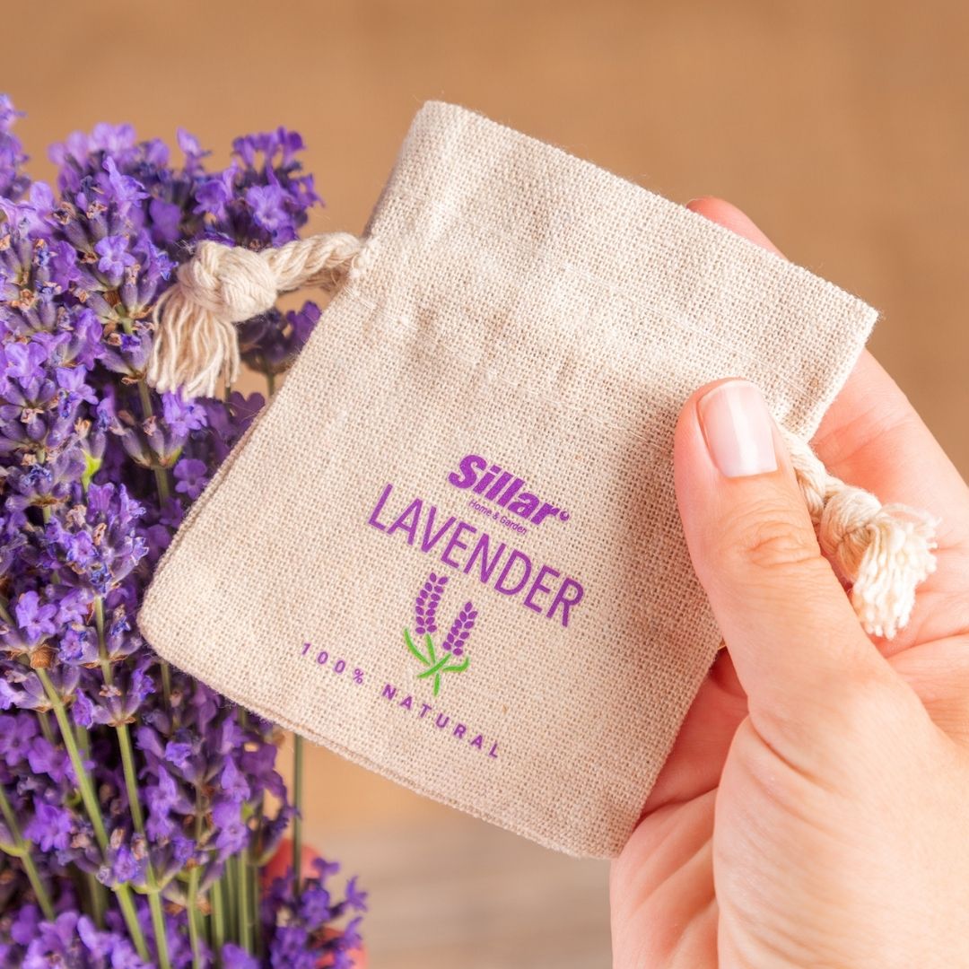 Cotton pouch with purple lavender print, held in hand.