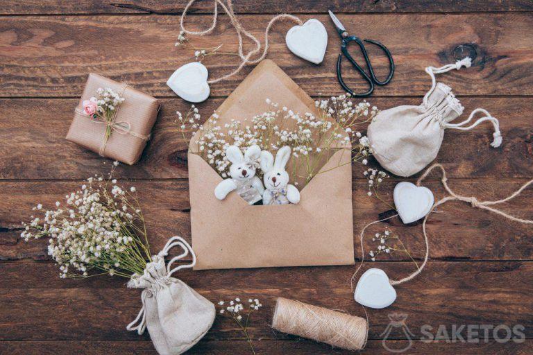 A linen bag with a plaster, plush bunnies in an envelope and a gift wrapped in gray paper.