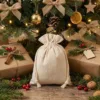 Linen bags under Christmas tree with decorations - festive gift packaging