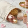 Linen bags with skincare cosmetics on a marble surface