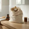 Linen bag on a bathroom shelf with cosmetics and skincare accessories in a bright interior