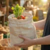 Linen bag with vegetables and herbs held in hands in an organic shop