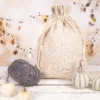 Linen bag with drawstring on a decorative background with pumpkins and yarn in autumn style