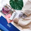 Linen bag as an organiser for travel accessories, book and glasses on a marble tabletop