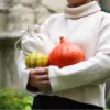 Linen bag held by a person with pumpkins as natural gift packaging