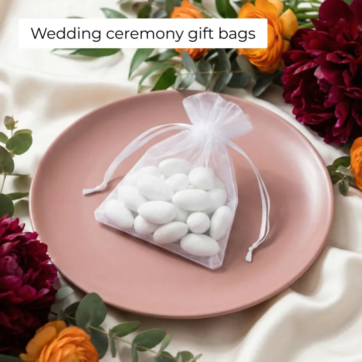 White organza bag with sugared almonds on a plate for wedding favours.